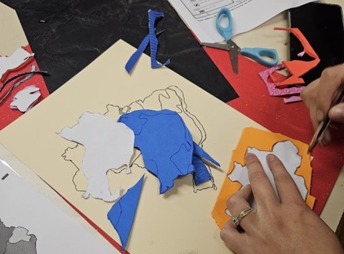 Photograph showing the manual process of creating tactile maps. The image shows the hands of workshop participants using hot glue guns and precision applicators to apply raised lines, dots, and textures onto sheets with a cartographic base.